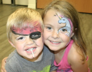 Siblings Hudson and Adalynn Victory, 2 and 5 respectively, of Lake Orion, were all smiles while sporting their pirate and unicorn face paintings and waiting to play some of the carnival games. Photo by Cathy Kimmel-Srock.