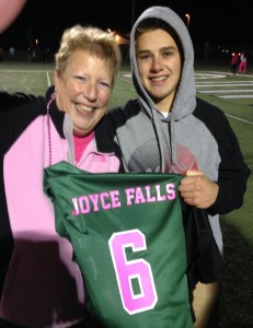 Orion resident Joyce Falls is presented with a jersey in her honor by player Connor O’Dea at last year’s event. Falls, a cancer survivor, knew O’Dea, now a Lake Orion graduate, from when he was a student at Oakview Middle School. Photo submitted.