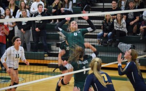 Senior Mallorie Berriman, no. 8,  jumps to spike the ball during the district championship against Clarkston on Friday. Berriman had 11 kills in the match. Photo by Jim Newell