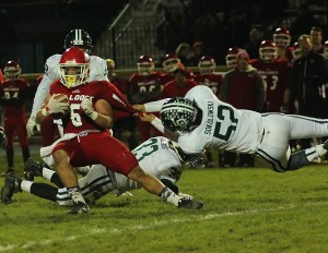 Junior Dustin Sokolowski (52) pulls down Romeo’s running back for a loss in the first quarter.  Photo by Joe St. Henry