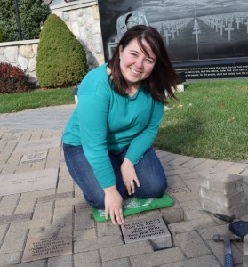 Alana Hart places a commemorative stone honoring her late father, Alan C. Hart, at the Veterans Memorial.