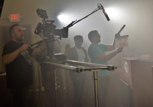 Cinematographer Istvan Lettang films the scene as Director/Producer Sam Logan Khaleghi (center, white shirt) gives direction and calls for "Action."