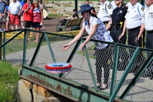 American Legion Post 233 Ladies Auxiliary President Robin Cram (above) commits a wreath to Paint Creek from the bridge at Children's Park to honor those veterans lost at sea. Cram's father, Kenneth Smith, is a Vietnam veteran and the Lake Orion Honored Veteran for 2018. 