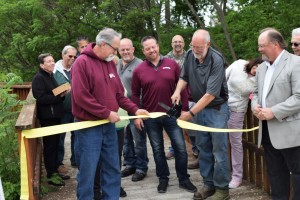 J.R. Nowells of Lake Orion Lumber cuts the ribbon during the Paint Creek Trail dedication ceremony during National Trails Day on Saturday. Lake Orion Lumber granted an easement through the lumberyard property, allowing construction of the trail.